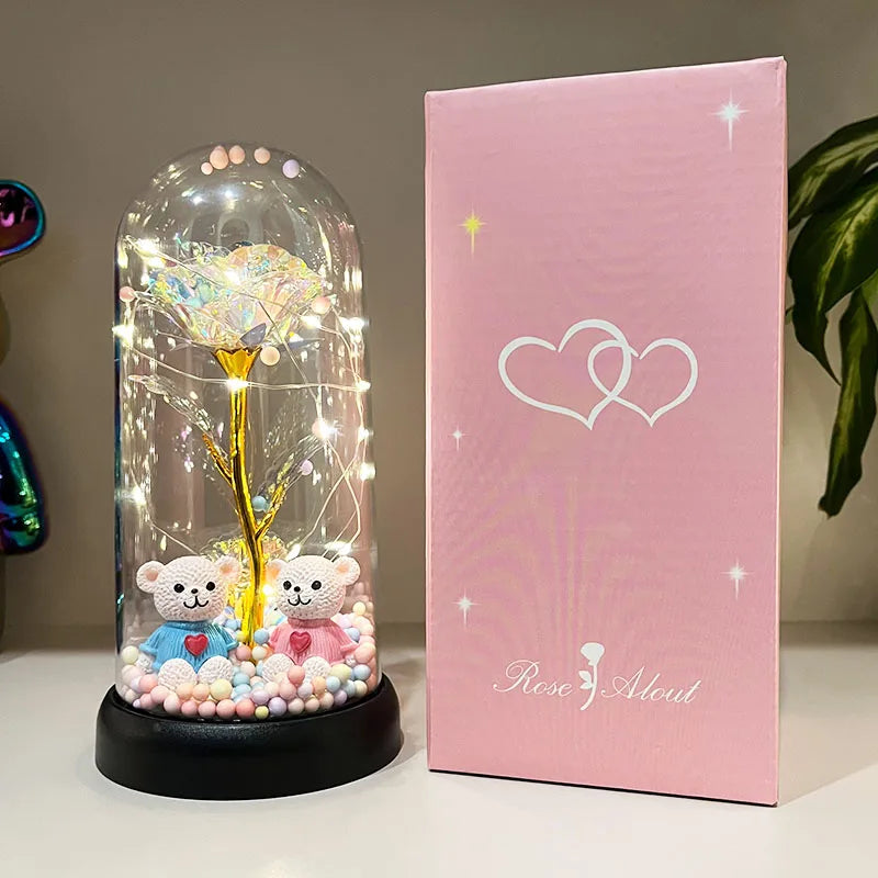 Frasco de vidrio transparente lleno de elementos decorativos rosa y blanco, junto a una caja rosa con un corazón blanco.