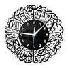 A black and white acrylic wall clock featuring intricate Arabic calligraphy designs around the face.