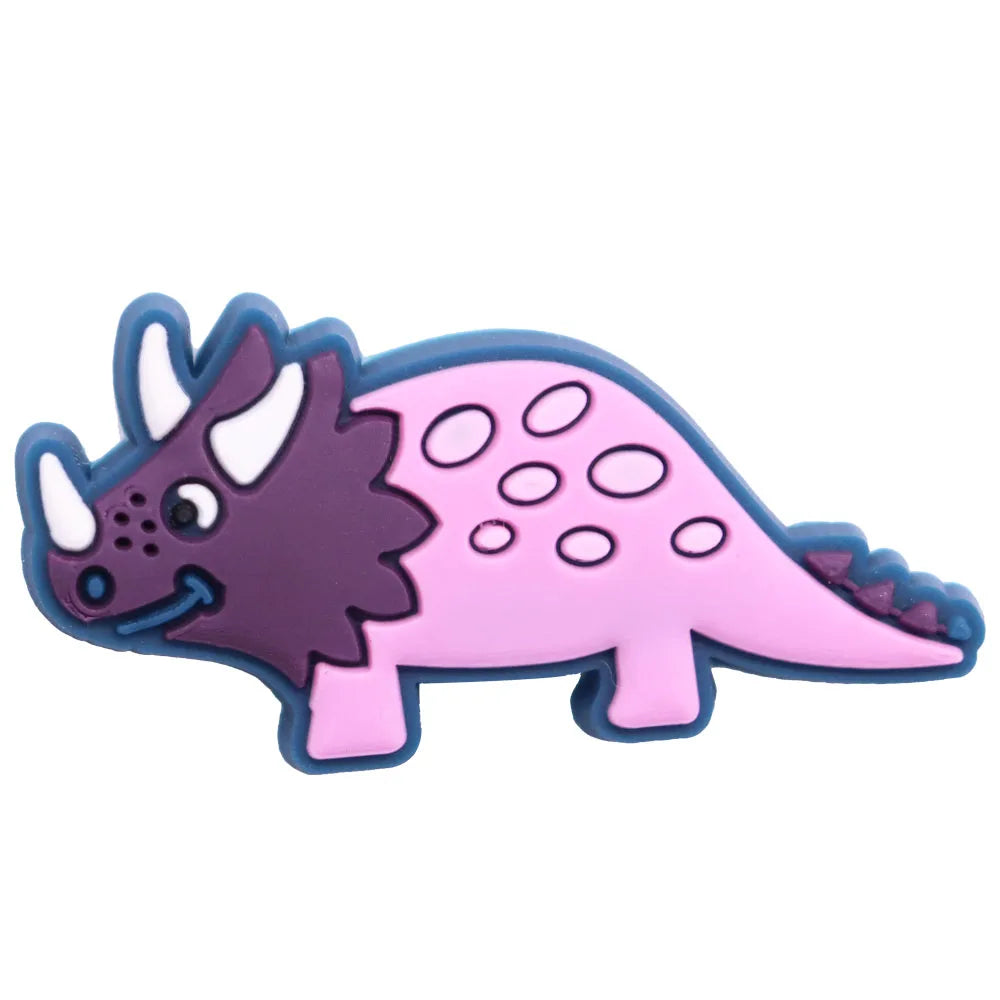 A set of twelve cartoon dinosaur PVC shoe charms featuring purple and pink dinosaurs.