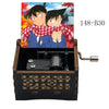 A wooden music box featuring an anime scene of two characters and a red plaid shirt.