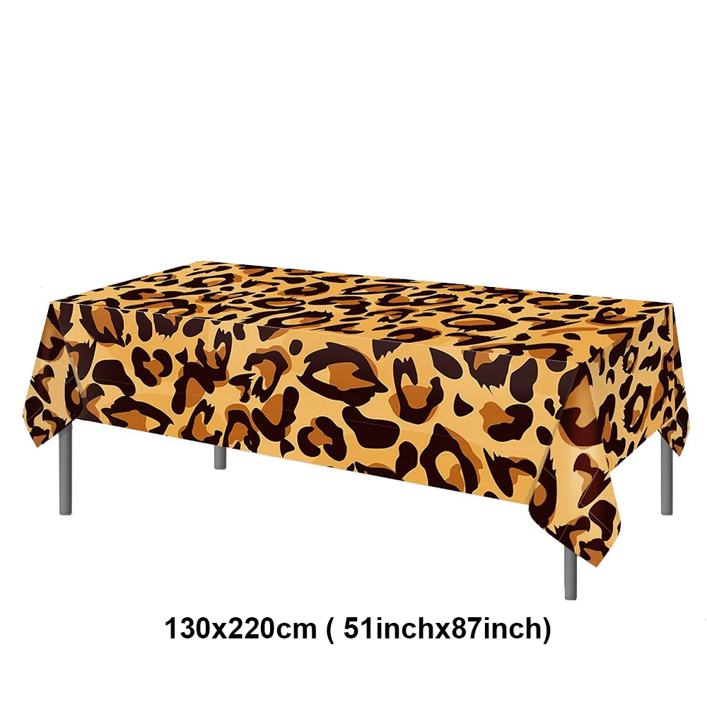 A rectangular table covered with a leopard print tablecloth for party decorations.