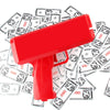 A red funny money shooter toy is shown lying on top of scattered US dollar bills.