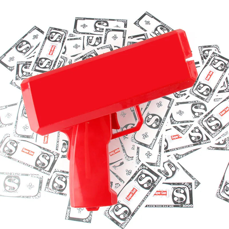 A red funny money shooter toy is shown lying on top of scattered US dollar bills.