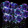A cluster of glowing LED illuminated balloons in shades of purple and blue, sparkling with tiny lights.