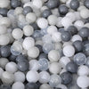 A pile of colorful, translucent, and opaque spherical plastic balls in various shades of white, gray, and light blue.