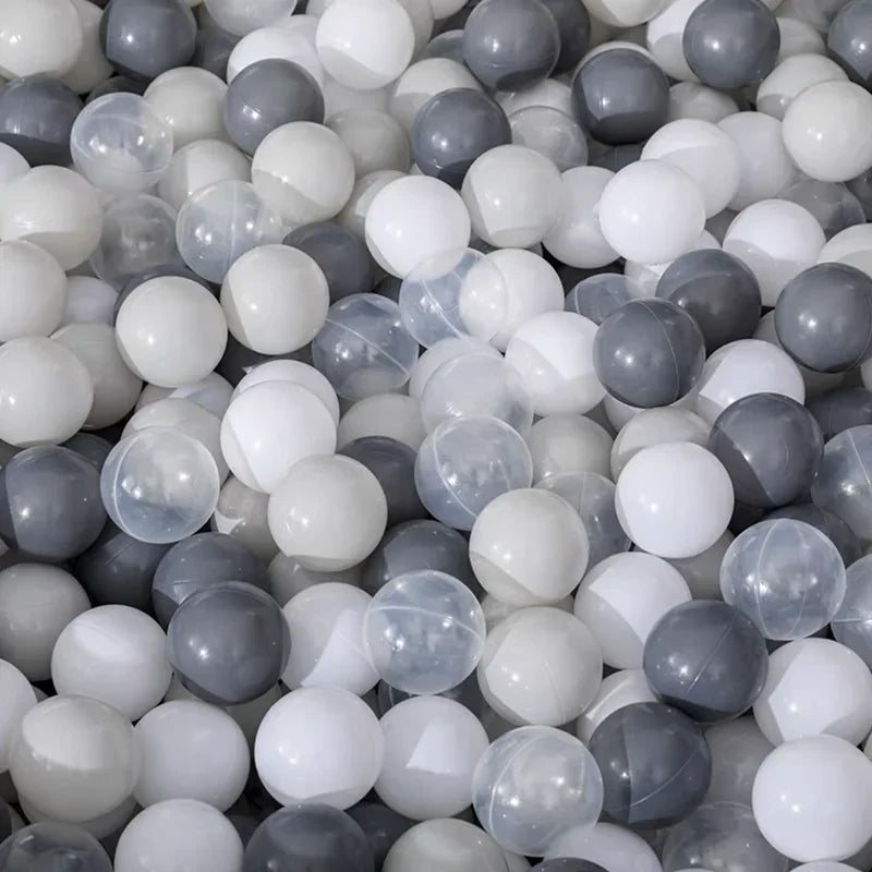 A pile of colorful, translucent, and opaque spherical plastic balls in various shades of white, gray, and light blue.