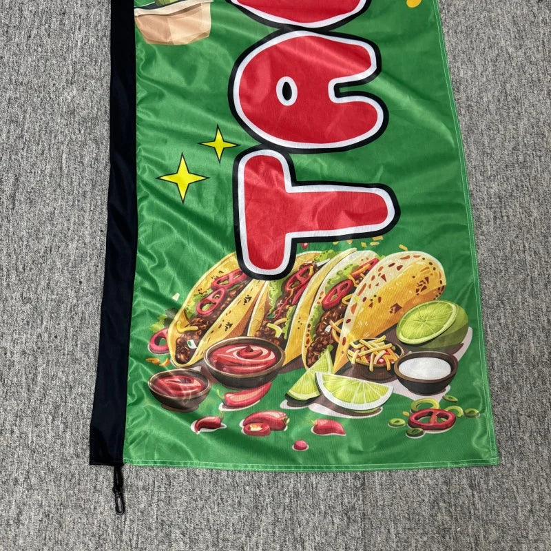 A green feather flag advertising banner featuring a large red taco design with various Mexican food ingredients.