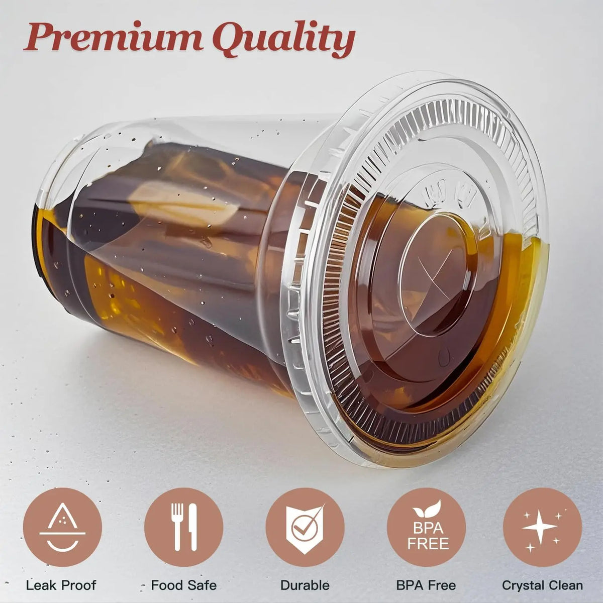 Clear plastic disposable cup with a lid and straw filled with amber liquid