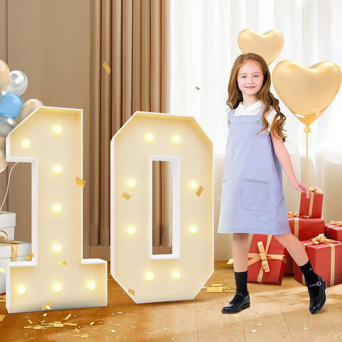 A young girl stands next to large illuminated number balloons spelling '10' in a light marquee frame.