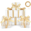 A set of clear PET favor boxes with gold ribbons and tags, including a roll of ribbon.