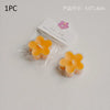 One piece of a yellow flower tea light candle in clear packaging with a pink floral sticker.