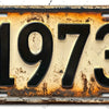 Letrero de aluminio vintage con el año 1973 grabado en una superficie desgastada y envejecida.