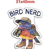A bird nerd acrylic flatback charm featuring a colorful blue and yellow bird standing on its feet.
