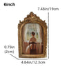 A vintage resin rotating photo frame with an ornate gold frame displaying a portrait.