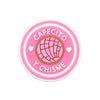 Pink PVC shoe charm with the text cafecito y chisme and a globe design