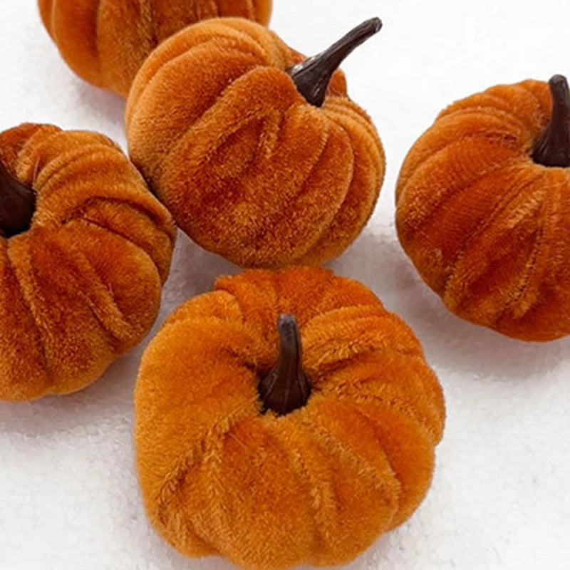 A set of five small, fuzzy orange foam pumpkins used for Halloween decoration.