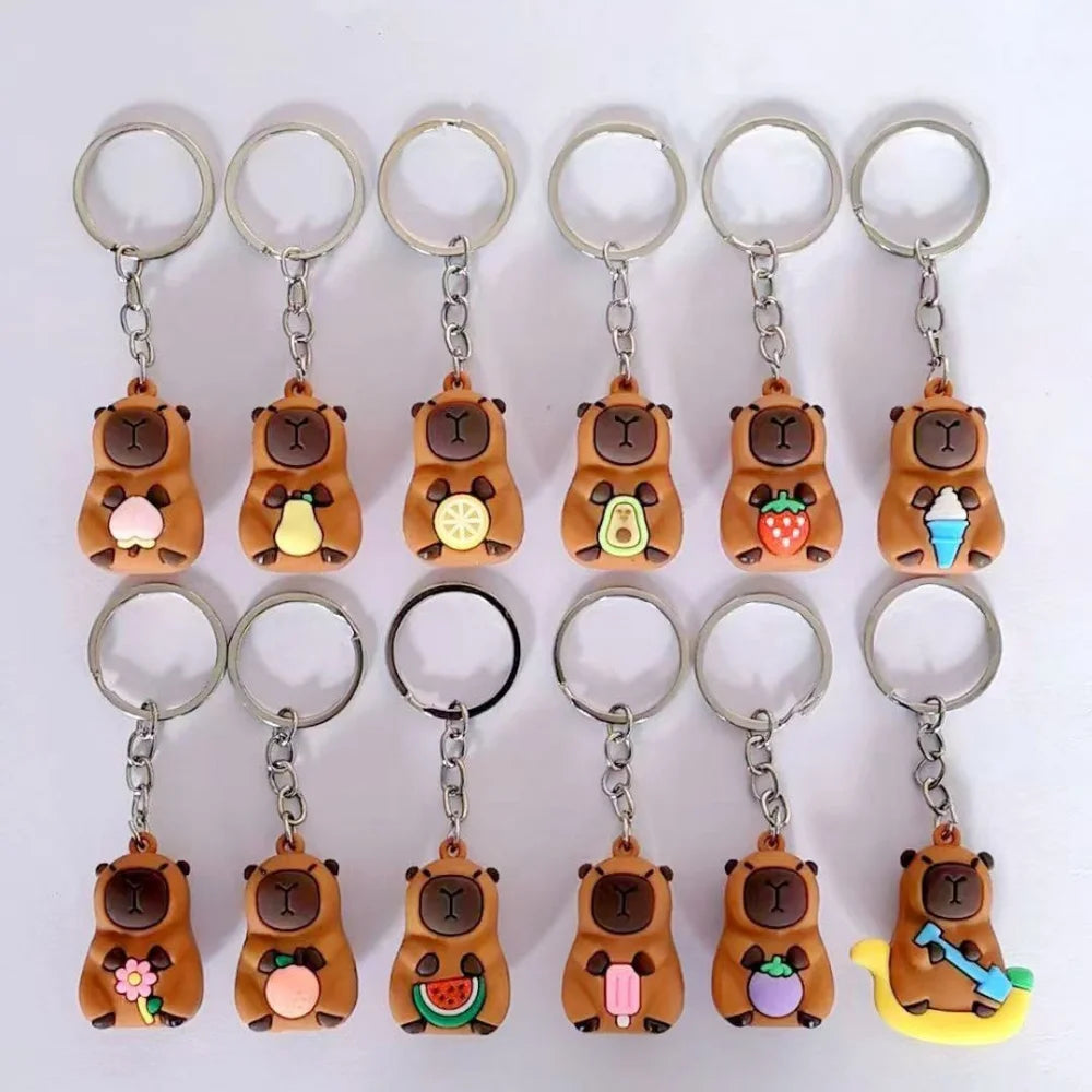 Un ensemble de clés et pendentifs à thème capybara dans des tons marron et jaune.
