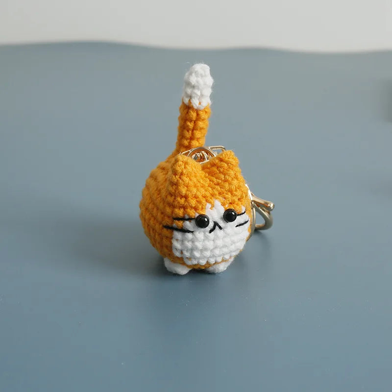 Handcrafted crochet cat keychain pendant in orange and white yarn