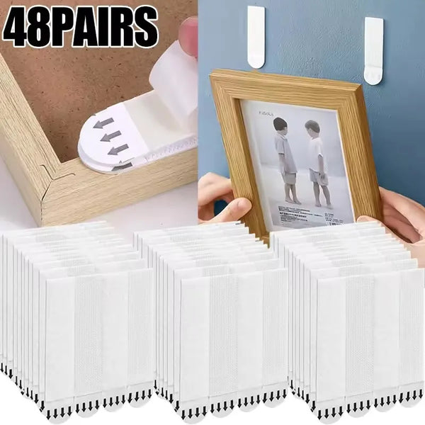 A set of 48 pairs of white reusable double-sided adhesive picture hanging strips shown next to a wooden frame and a white str