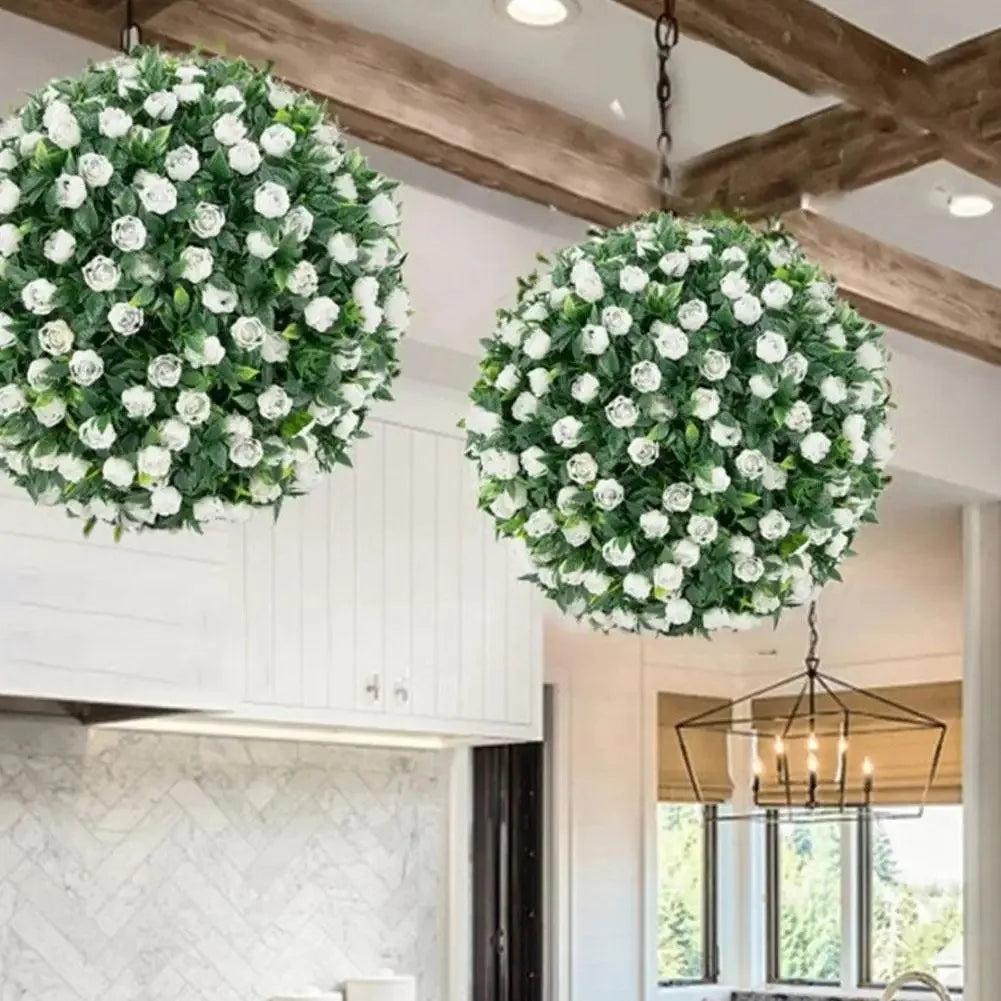 A large artificial rose ball decorative floral sphere hangs from a wooden ceiling beam.