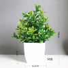 A potted artificial bonsai plant with bright green eucalyptus leaves in a white cylindrical pot.