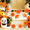 An arrangement of artificial orange marigold and carnation flowers used for festive Halloween decor.