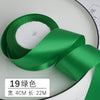 Ruban décoratif en satin vert avec garnissage blanc, mesure 4 cm de large et 22 mètres de long.