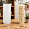 A white embossed pillar mold and a beige candle are displayed on a wooden surface.
