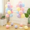 A vertical column of pastel pink, yellow, and blue balloons displayed on a stand.