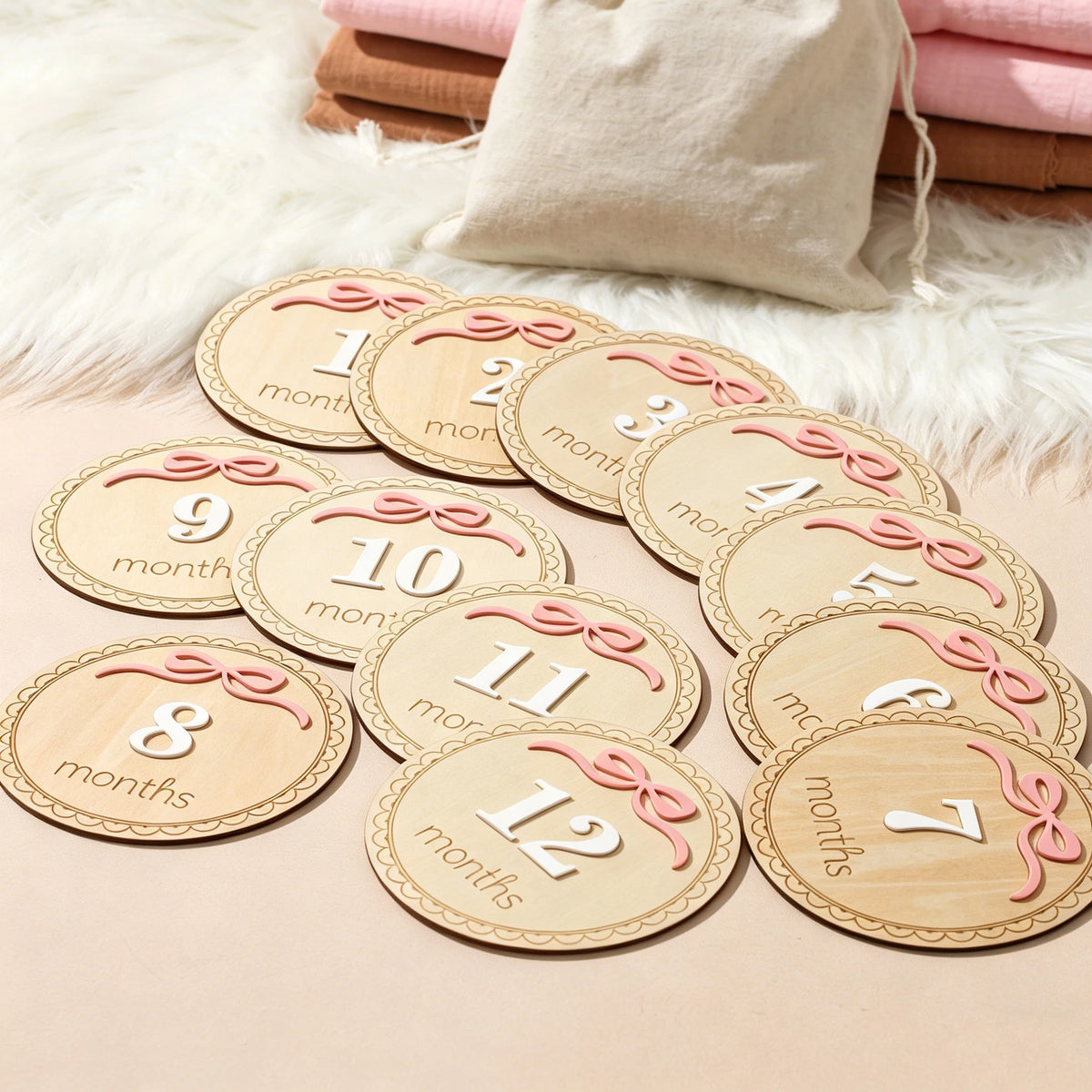A set of wooden baby milestone cards showing numbers 1 through 12 for newborn keepsakes