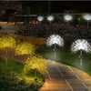 A row of solar fireworks garden lights illuminating a pathway and flower bed at night.