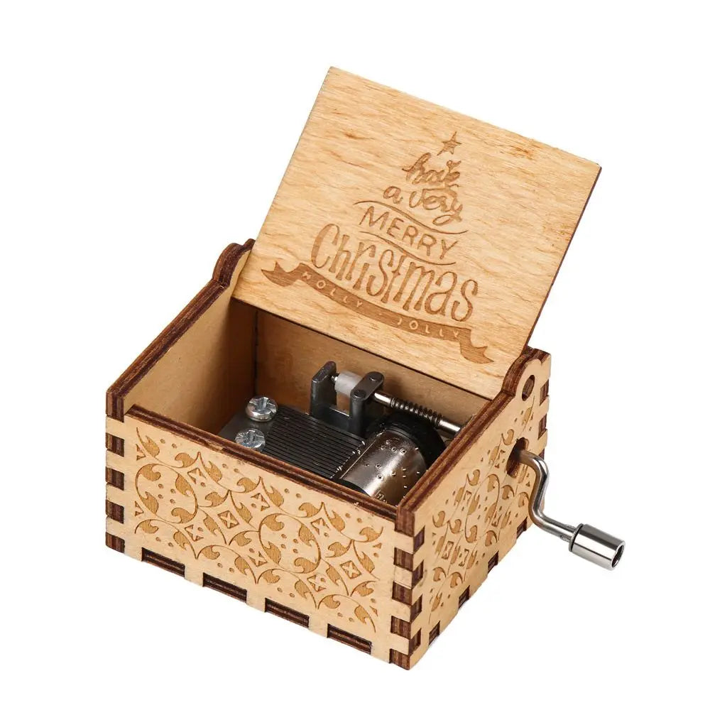 A vintage hand-cranked wooden music box with a lid engraved 'Have a Merry Christmas' and decorative wood grain.