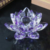 A clear crystal lotus flower ornament with purple and violet facets, displayed on a dark surface.