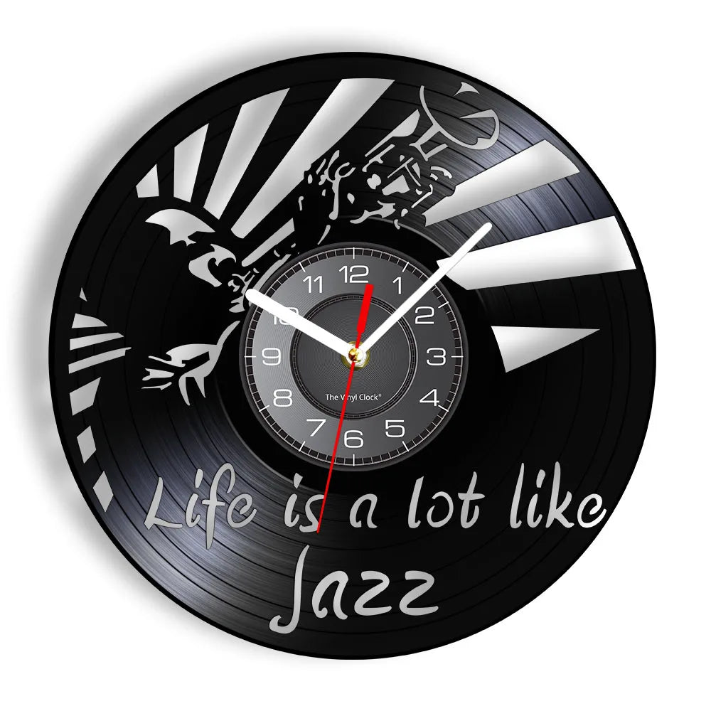 A black vinyl record wall clock with a white face and silver markings, showing the time.