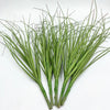 A bundle of artificial grass greenery with long, thin green blades.
