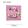 A pink floral napkin with various colored flowers and leaves.