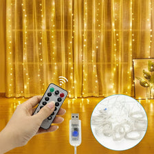 A hand holds a remote control for USB LED curtain lights, with a close-up view of the tangled LED wires.