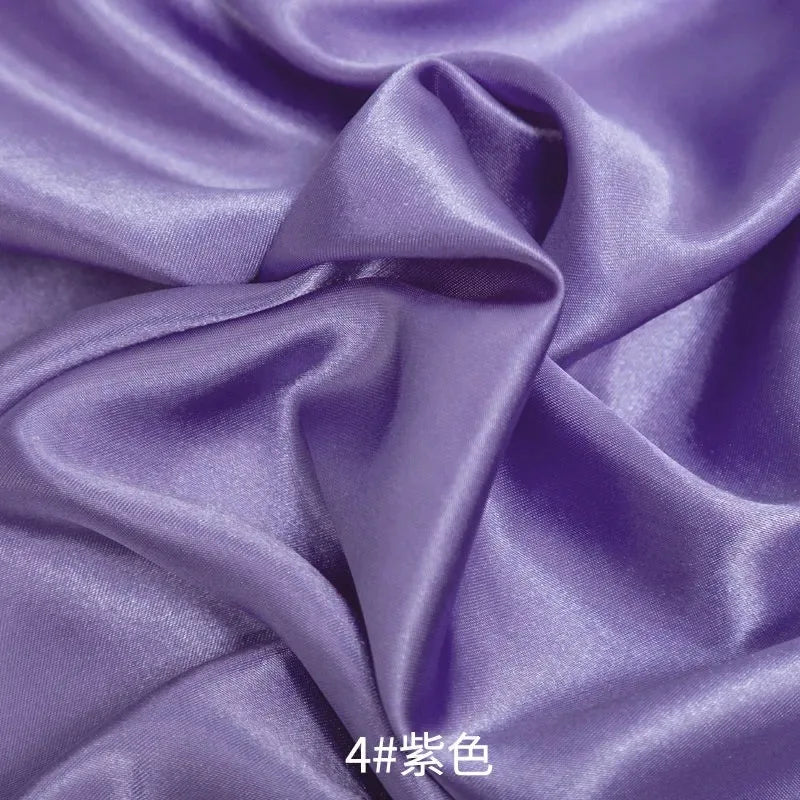 Purple satin fabric draped and folded for sewing or DIY projects