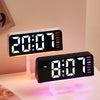A black digital alarm clock with a bright display and pink mood light is shown on a white surface.