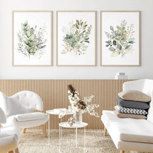 A set of three watercolor botanical prints featuring wild flowers and greenery on canvas wall art