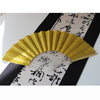 A golden glitter folding fan with transparent ribs is displayed against a black background with Japanese calligraphy.