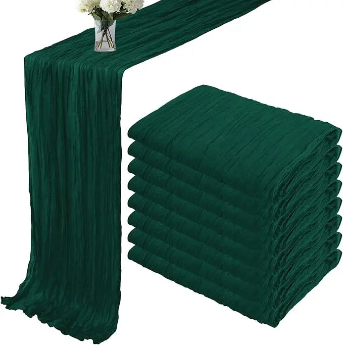 A set of dark emerald green terracotta semi-sheer cheesecloth table runners displayed on a table.