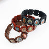 A bracelet made of dark wood beads featuring charms depicting the Virgin Mary and Jesus.
