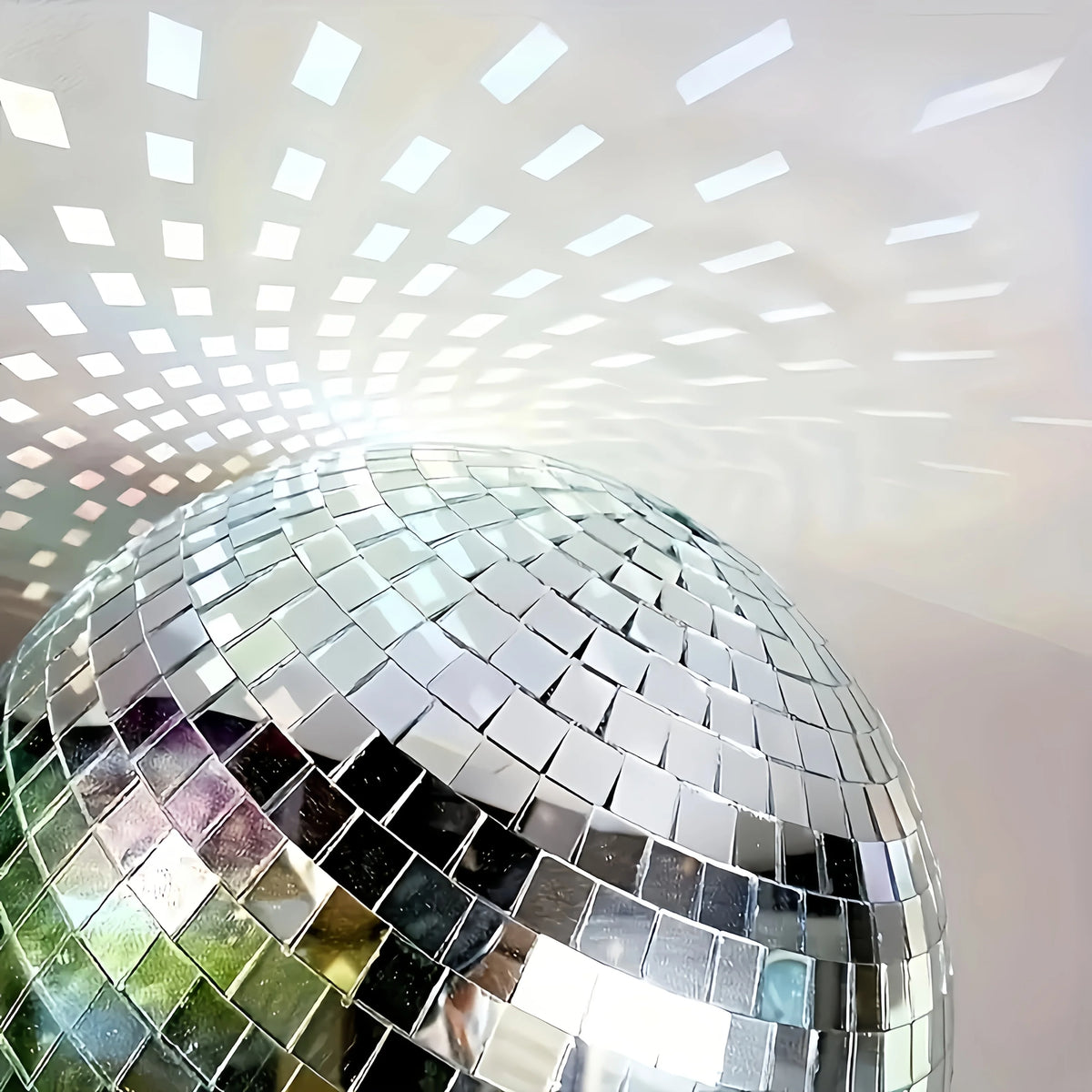 A close-up of a silver disco ball reflecting light and creating a starburst pattern.