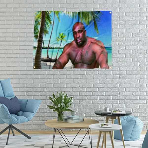 Póster de un hombre musculoso con barba y tatuajes contra un fondo tropical.