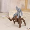 A collectible figurine set featuring a brown, monstrous hand gripping a gray, humanoid figure.
