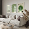 A modern living room featuring a light sofa and three framed Bauhaus art prints on the wall.