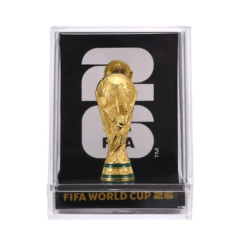 A gold-colored trophy figurine of the FIFA World Cup 2026 trophy displayed in a clear box.