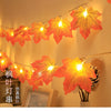 An autumn leaf garland with warm LED lights is displayed against a light background.