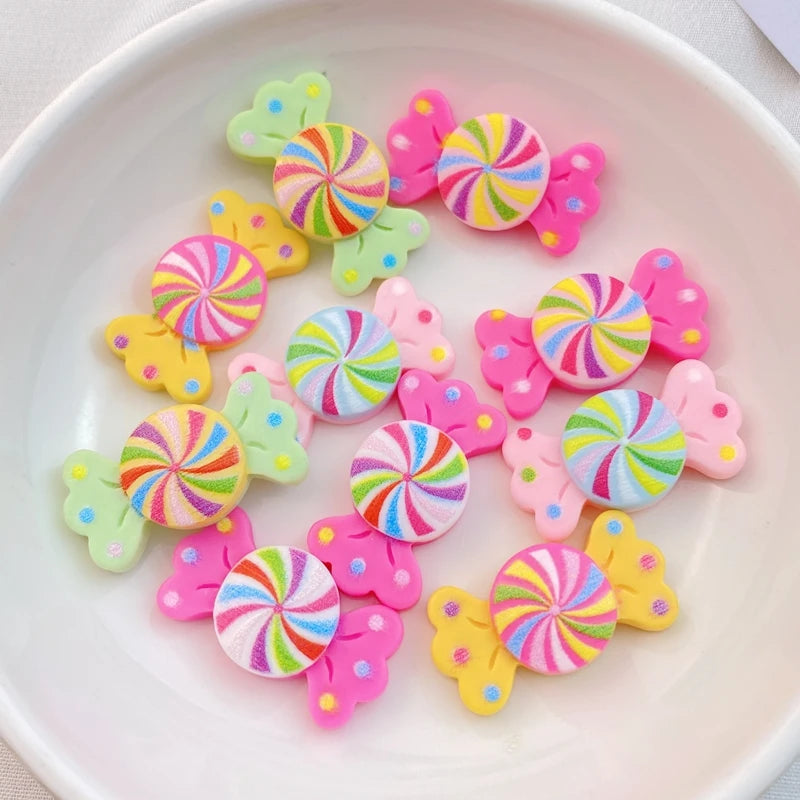 A collection of 20 colorful resin candy charms in various swirl patterns and pink, green, and yellow shapes.